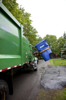 Workers using PPE to load a skip safely